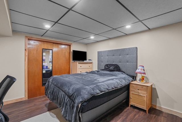 bedroom featuring dark hardwood / wood-style floors and a drop ceiling