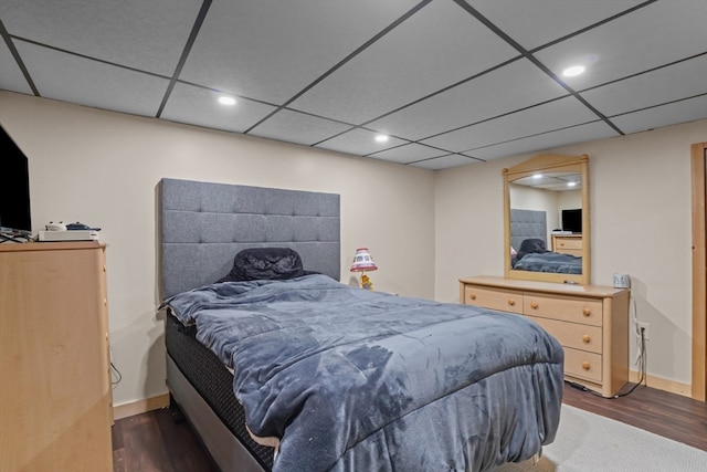 bedroom featuring dark hardwood / wood-style flooring and a drop ceiling