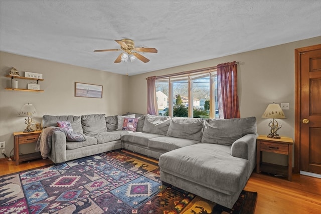 living room featuring ceiling fan, a textured ceiling, and light hardwood / wood-style flooring