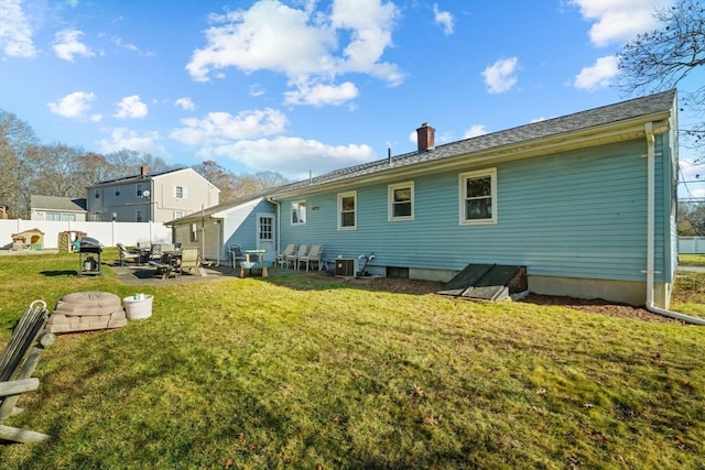 back of property with central AC, a patio area, and a lawn