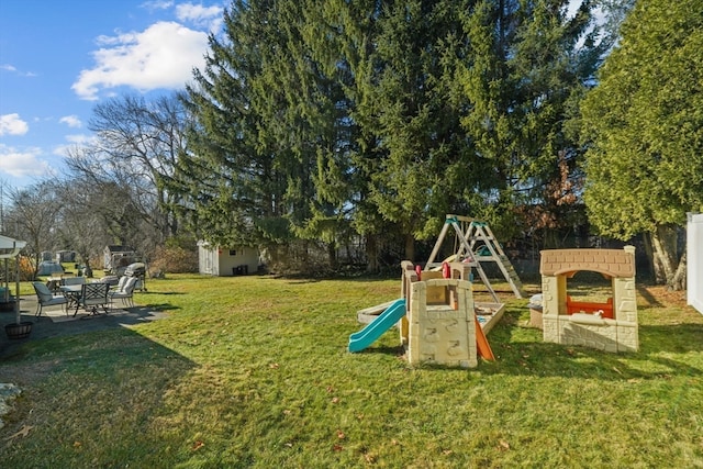 view of jungle gym featuring a lawn and a storage unit