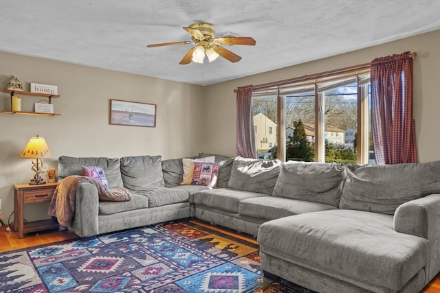 living room with ceiling fan, a textured ceiling, and hardwood / wood-style flooring