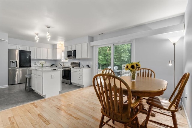 70 Granby Hts Unit 70, Granby, MA 01033 - kitchen featuring appliances with stainless steel finishes, white cabinetry, a kitchen island, light countertops, and light wood finished floors