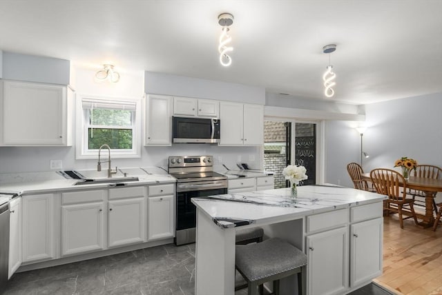 70 Granby Hts Unit 70, Granby, MA 01033 - kitchen with stainless steel appliances, white cabinets, a center island, and a kitchen bar