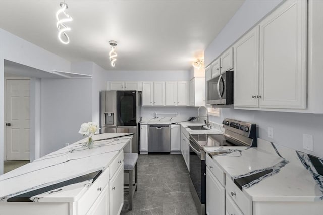 70 Granby Hts Unit 70, Granby, MA 01033 - kitchen featuring appliances with stainless steel finishes, a kitchen island, white cabinets, and light stone counters