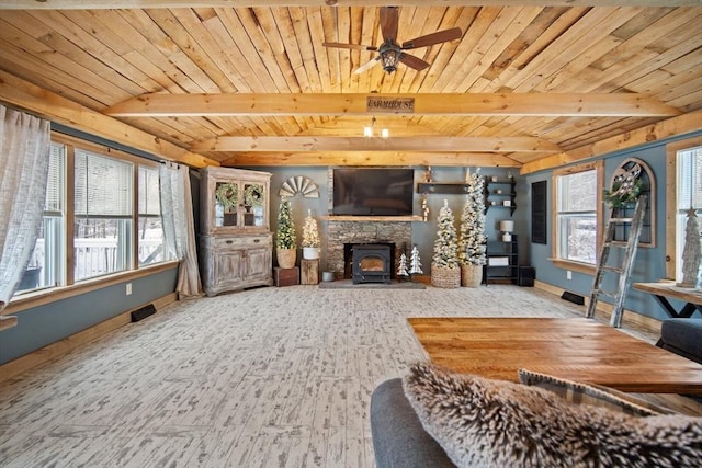 living room with wooden ceiling, beamed ceiling, a wood stove, and ceiling fan