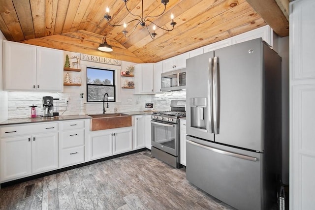 kitchen with light hardwood / wood-style floors, white cabinets, appliances with stainless steel finishes, and wooden ceiling