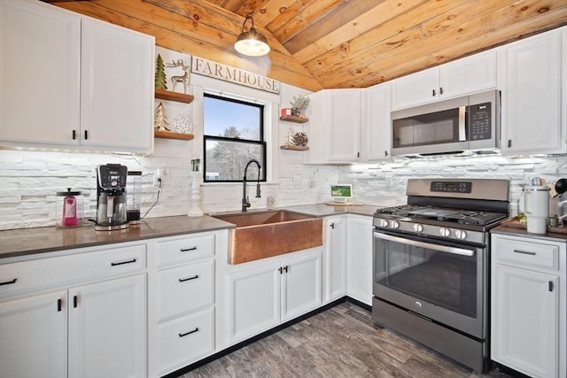 kitchen with sink, white cabinetry, stainless steel appliances, and vaulted ceiling