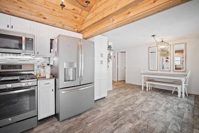 kitchen with decorative light fixtures, white cabinets, and appliances with stainless steel finishes