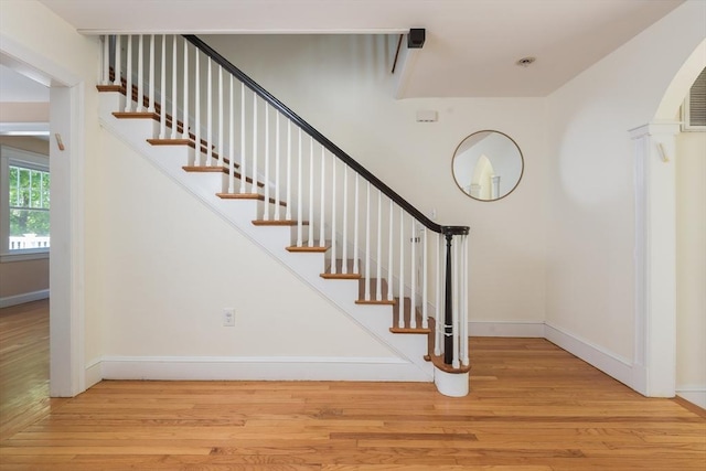 staircase with wood finished floors and baseboards
