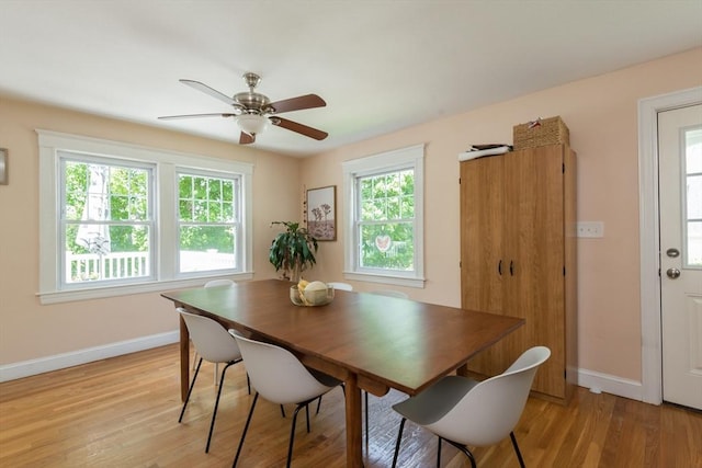 dining space featuring baseboards, light wood-style floors, and a ceiling fan