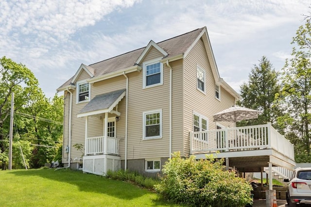 rear view of house with a yard and a wooden deck