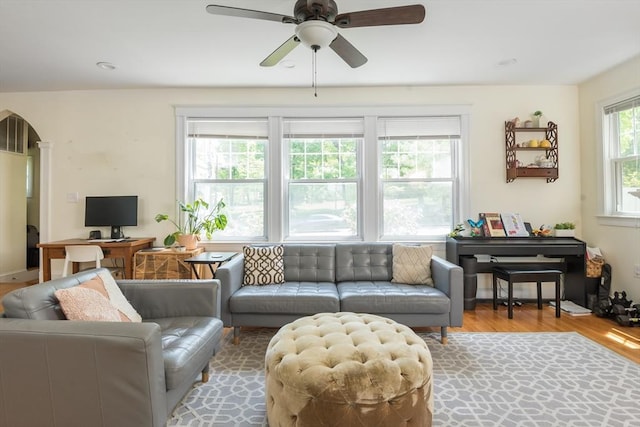 living room featuring ceiling fan, wood finished floors, and arched walkways
