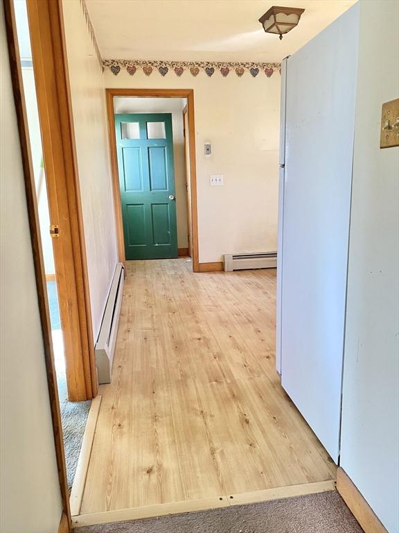 corridor featuring hardwood / wood-style floors and baseboard heating