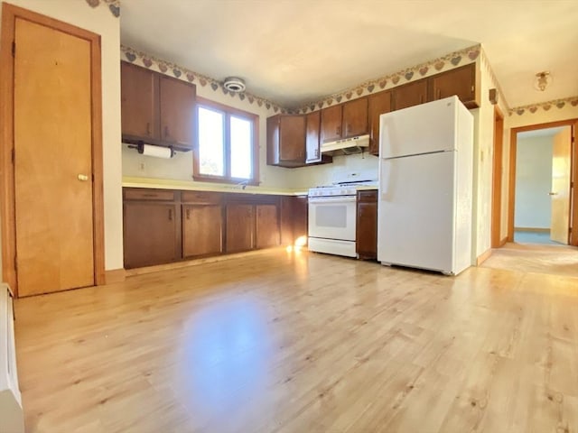 kitchen featuring light wood-type flooring and white appliances