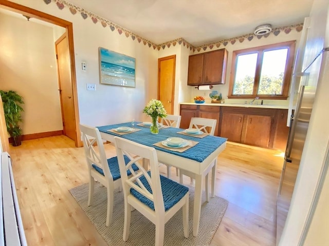 dining room with light hardwood / wood-style flooring and sink