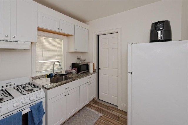 13 Main St, Framingham, MA 01702 - kitchen with white appliances, under cabinet range hood, white cabinetry, light wood-style floors, and dark stone counters