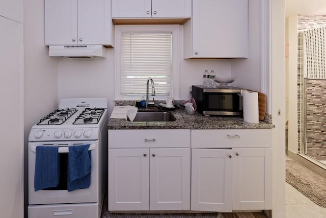 13 Main St, Framingham, MA 01702 - kitchen with gas range gas stove, under cabinet range hood, stainless steel microwave, white cabinets, and dark stone countertops