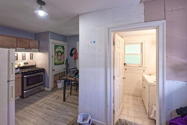 13 Main St, Framingham, MA 01702 - kitchen with stainless steel range with gas stovetop, freestanding refrigerator, and under cabinet range hood
