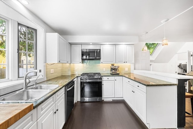 11 N Hancock St, Lexington, MA 02420 - kitchen with appliances with stainless steel finishes, a sink, a peninsula, white cabinets, and tasteful backsplash