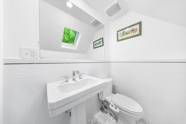 11 N Hancock St, Lexington, MA 02420 - half bath featuring vaulted ceiling, a skylight, tile walls, toilet, and a wainscoted wall
