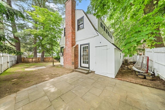 11 N Hancock St, Lexington, MA 02420 - back of house featuring a patio area, a chimney, and a fenced backyard