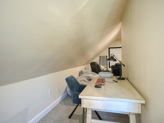 carpeted home office with vaulted ceiling