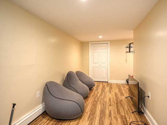 living area featuring a baseboard heating unit and light wood-type flooring