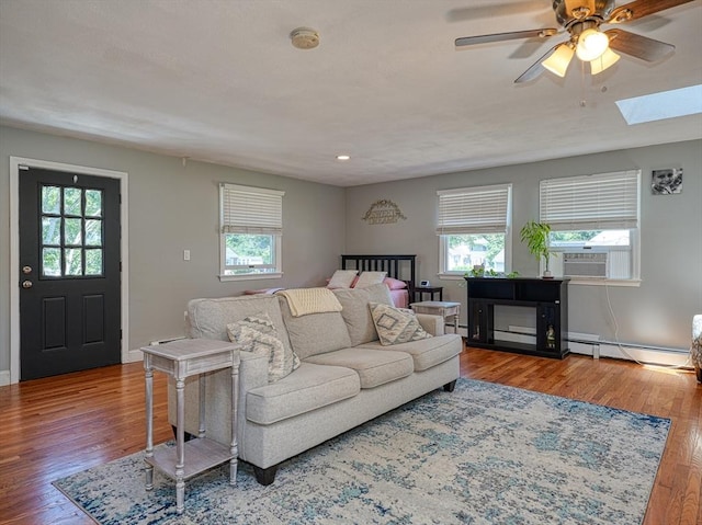 19 Mohawk Rd, Burlington, MA 01803 - living area with wood finished floors, a ceiling fan, a skylight, baseboard heating, and a baseboard radiator