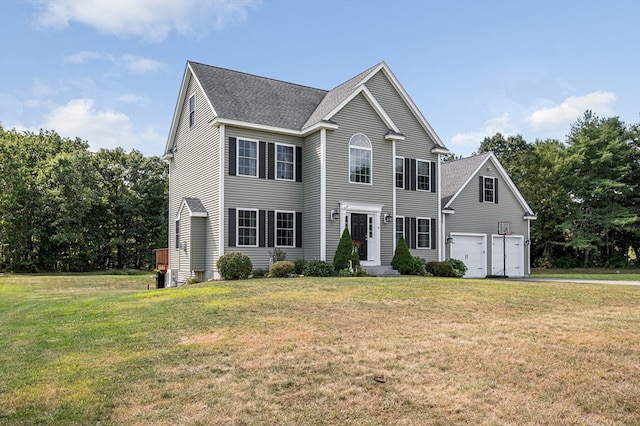 colonial inspired home featuring a garage and a front lawn