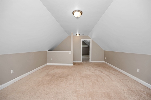 bonus room with vaulted ceiling and light carpet