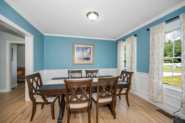 dining room featuring light wood-type flooring and ornamental molding