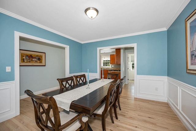 dining area with light hardwood / wood-style floors and ornamental molding