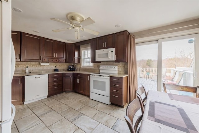 kitchen with light countertops, white appliances, a sink, and tasteful backsplash