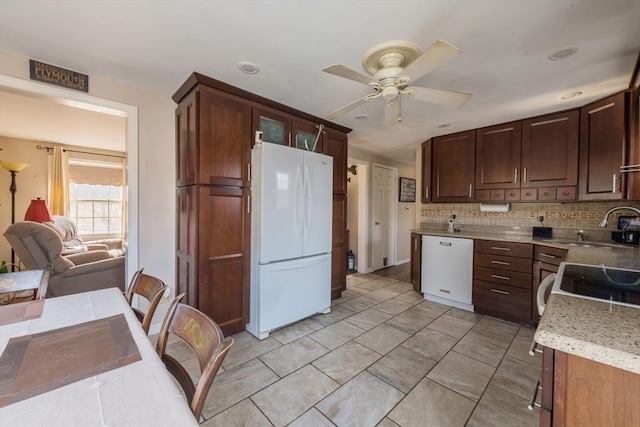 kitchen featuring white appliances, light tile patterned floors, ceiling fan, a sink, and backsplash