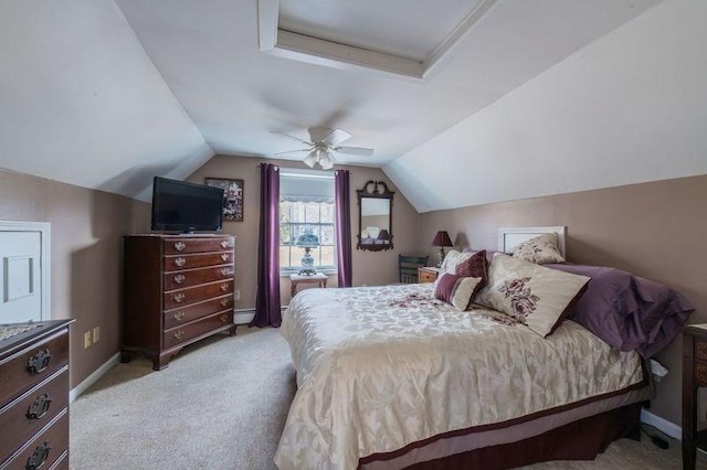 bedroom featuring lofted ceiling, baseboards, a ceiling fan, and light colored carpet