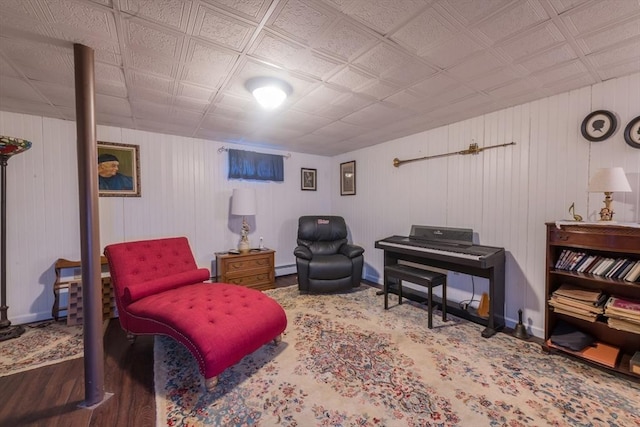 sitting room featuring a baseboard heating unit, wood finished floors, and baseboards