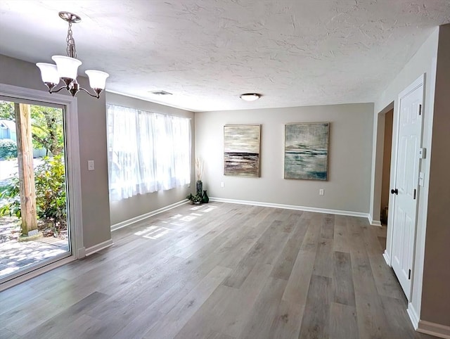 3202 Halcyon Dr Unit 3202, Worcester, MA 01606 - unfurnished dining area with a chandelier, healthy amount of natural light, wood finished floors, and a textured ceiling