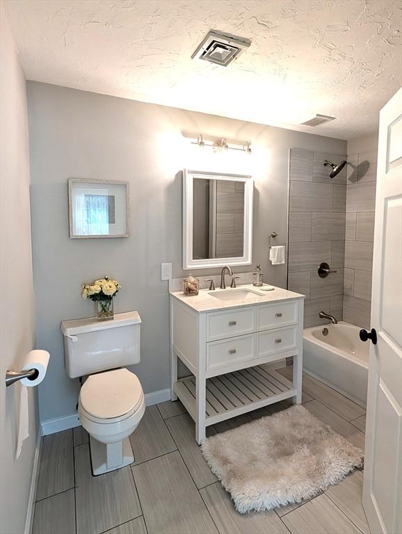 3202 Halcyon Dr Unit 3202, Worcester, MA 01606 - full bathroom featuring vanity, washtub / shower combination, a textured ceiling, and wood tiled floors
