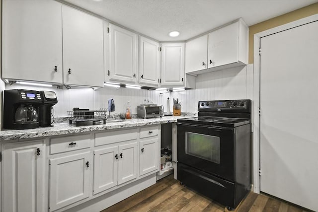 175 Armsby Rd, Sutton, MA 01590 - kitchen with black range with electric stovetop, white cabinets, dark wood-style floors, light stone counters, and a textured ceiling