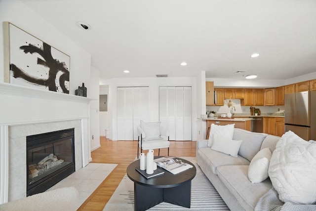 7 Conant Rd Unit 23, Winchester, MA 01890 - living room with electric panel, light wood finished floors, recessed lighting, and a tile fireplace