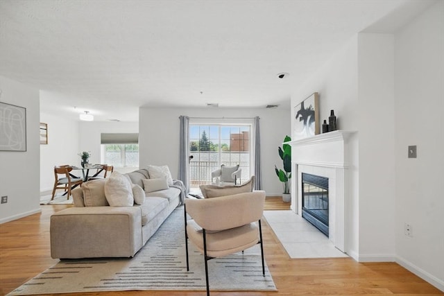 7 Conant Rd Unit 23, Winchester, MA 01890 - living area with light wood-style flooring, a tile fireplace, and baseboards