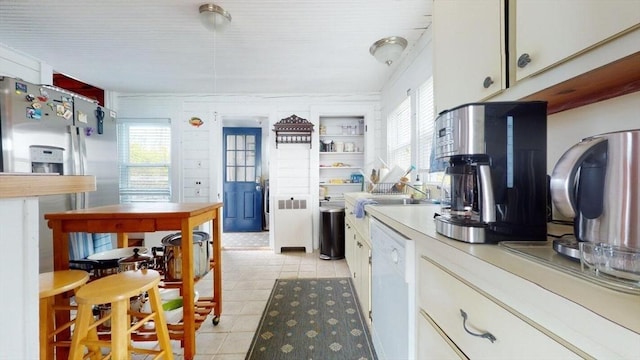 kitchen featuring white cabinetry, dishwasher, and light tile patterned floors