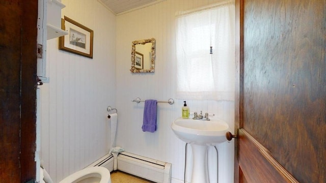 bathroom featuring a baseboard heating unit and toilet