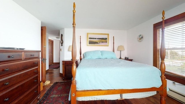 bedroom with dark wood-type flooring and a baseboard heating unit