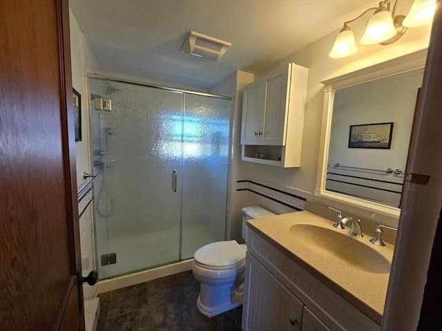 bathroom with vanity, toilet, and a shower with shower door