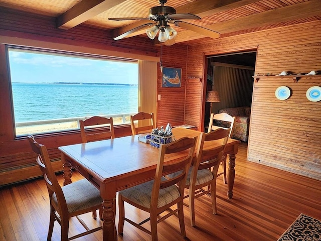 dining space with beam ceiling, ceiling fan, wooden ceiling, a water view, and hardwood / wood-style flooring