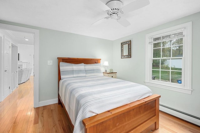 bedroom featuring a baseboard radiator, light wood-style flooring, baseboards, and attic access