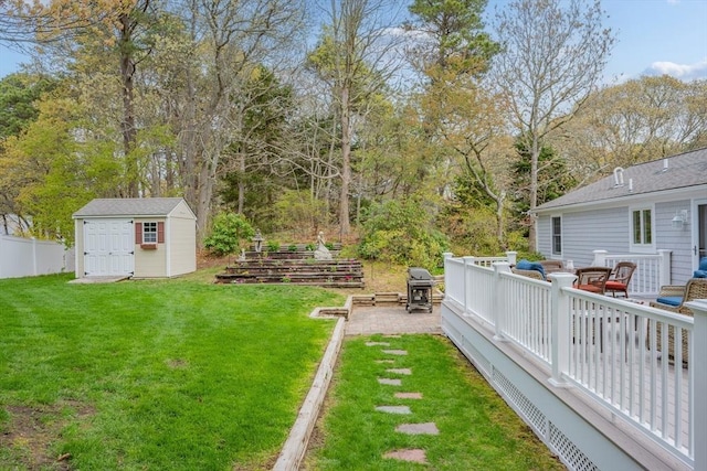 view of yard featuring a shed, an outbuilding, view of scattered trees, and a deck