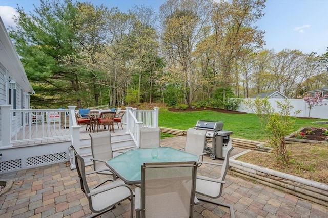 view of patio with outdoor dining area, area for grilling, and a wooden deck